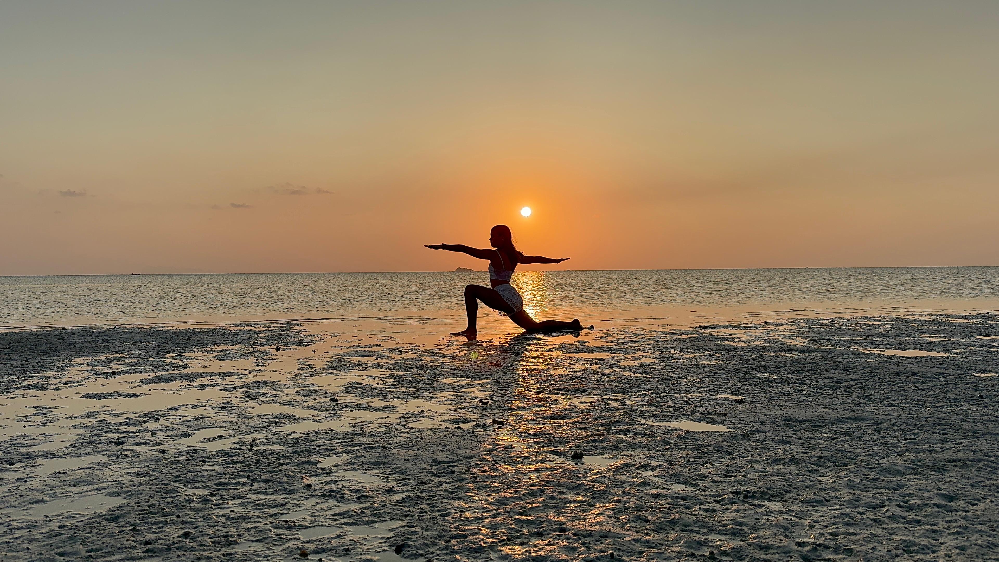 Adara doing yoga at sunset by the sea